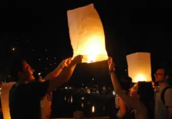 Launching a burning lantern during Loi Krathong