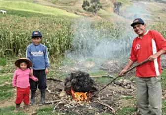 Walter and two of his children, Emerson and Angie, preparing the pachamanca