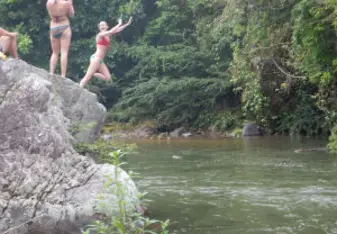 girls jumping off rocks into water