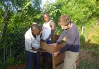 Matthias and KVCDP employees build a compost. 