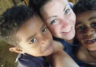 A teen volunteer with Fijian children