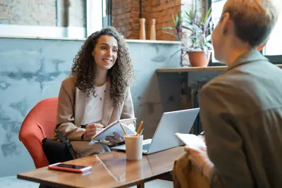 Counselor taking notes and sitting across table from student