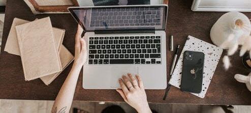 Hands of an online English teacher on a laptop keyboard