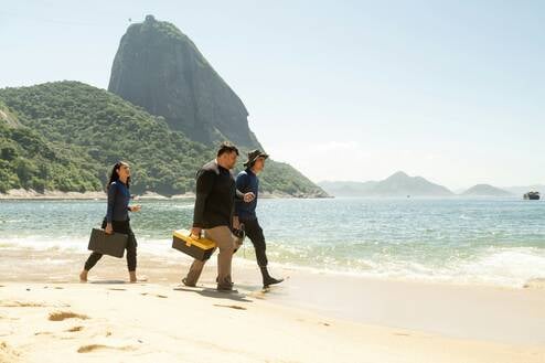 Three conservation volunteers walking across a beach 