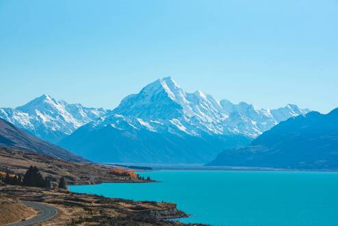 A road in New Zealand near lakes and mountains