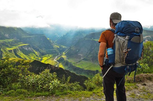 Ecuador: Food Revolutions man with a backpack looking out over mountains and green pastures