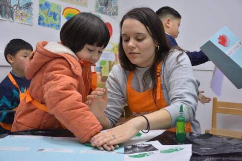 One of the alumni's from this program is pictured working with a student in China.