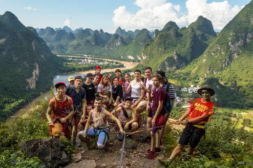 A group photos of students backdropped by Yangshuo landscape