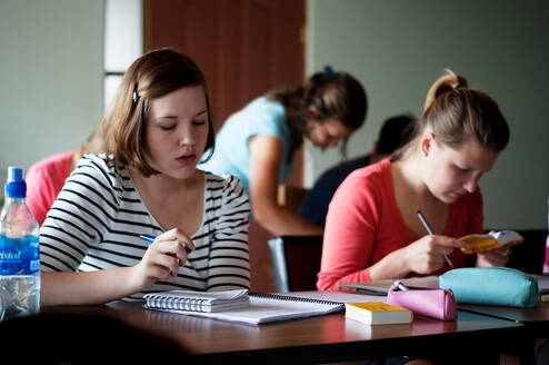 students sitting at a desk reading