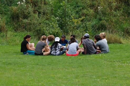 Participants in a circle outdoors 