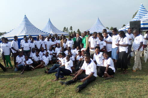 A  team of 4s volunteers posing posing for photo with South Korea Ambassador to Uganda 