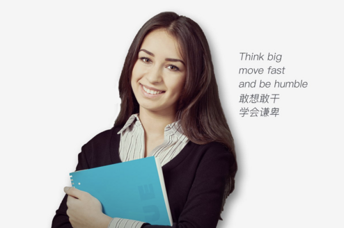 woman holding notebook and smiling in front of a white background