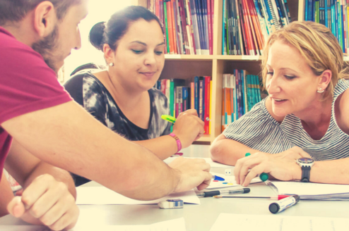 Teacher working with two learners. Text: Become the best teacher you can be
