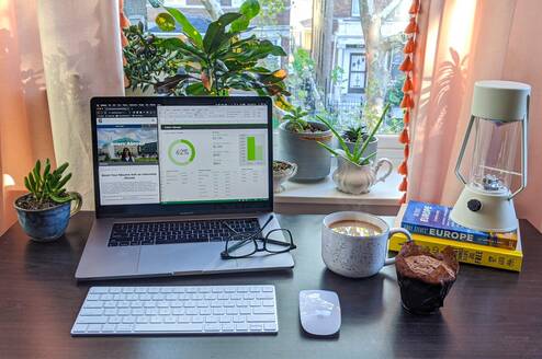 A desk with a laptop, glasses, and coffee - all ready for a day at your virtual internship!
