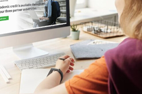 Young lady looking at the Japan Fuji Online website on a computer.