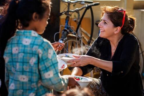 Volunteer helping with breakfast programme at community project in Cambodia