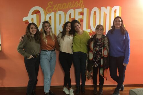 Six women standing together and smiling.