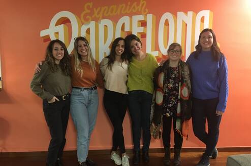 Six women standing together and smiling.