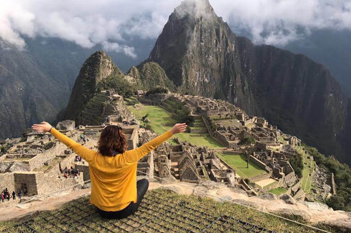 Woman sitting on top of Machu Picchu.