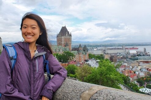 A girl posing with a city in the background.