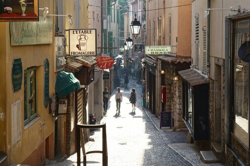 Two people walking down the street in France.