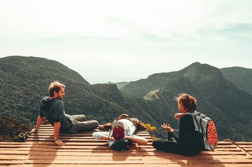 Three friends sitting in the mountains.