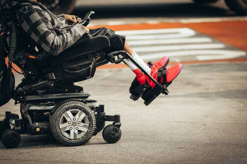 Person sitting in a wheelchair, red shoes