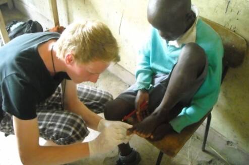 a medical volunteer removing jiggers in one of the students