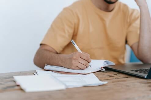 Student writing on paper