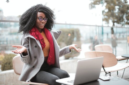 An online ESL teacher giving a lesson on her laptop outside