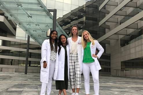 4 people wearing white coats