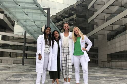 4 people wearing white coats