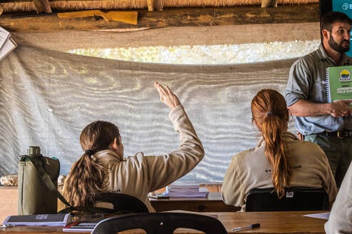 A Bushwise student raises her hand to ask a question during a lecture.