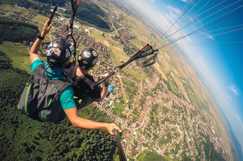 Two people parachuting over a city.