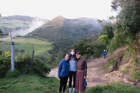 3 students standing in front of hills