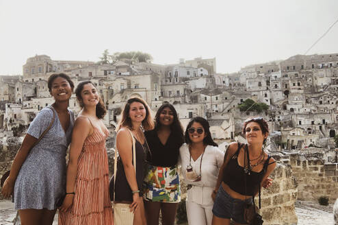 A group of women stand and pose for the camera smiling.