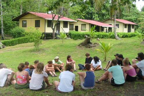 Students sitting in a circle on the grass at a field research station
