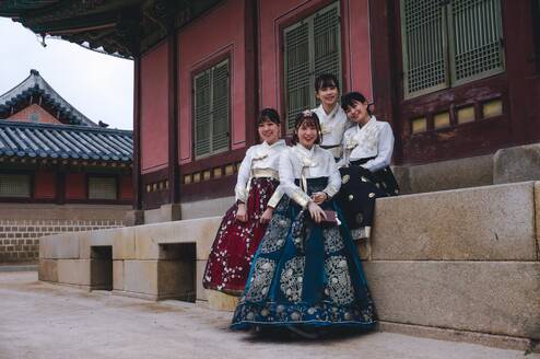 Four women in traditional Korea dress pose for a photo.