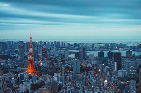 Panorama image a metropolis skyline with numerous high rises visible dwarfed by a tall red and white tower