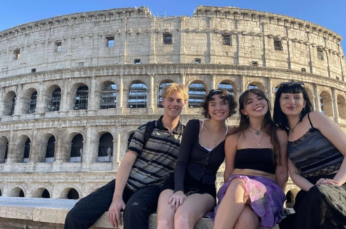Students smiling in front of colosseum
