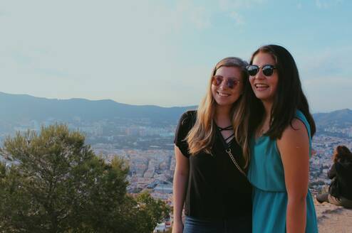 Friends abroad posing for a picture with a scenic background 
