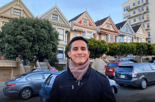 Young man poses in front of Painted Ladies in San Francisco