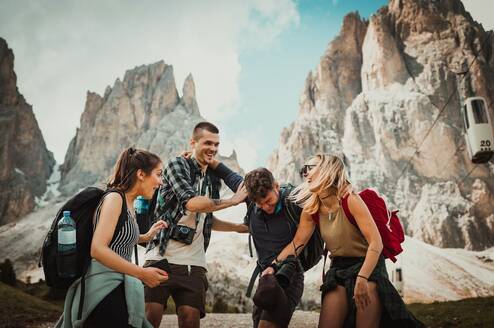 Friends laughing atop mountains 