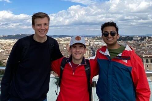 Students posing on overlook above city of Rome
