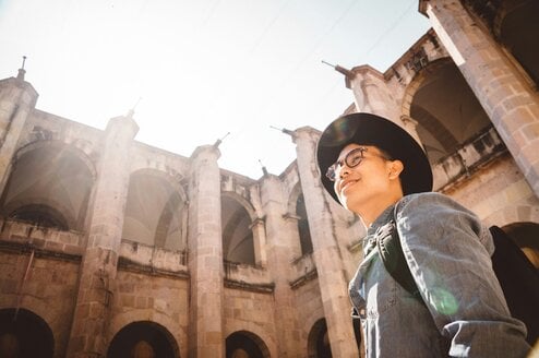 Man smiles with building in the background.