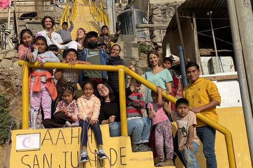 Children and volunteers in group on the stairs near the classroom