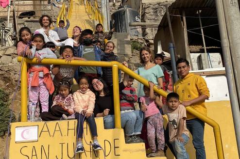 Children and volunteers in group on the stairs near the classroom
