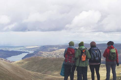 A group wearing backpacks looks at mountains.