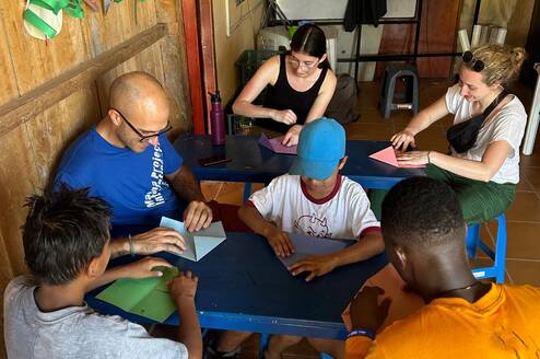 people sitting around table doing a craft