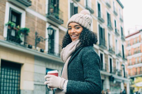 A woman smiles with apartments in Madrid in the background.